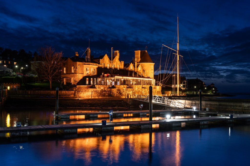 Alt text: The Royal Yacht Squadron club house illuminated at night