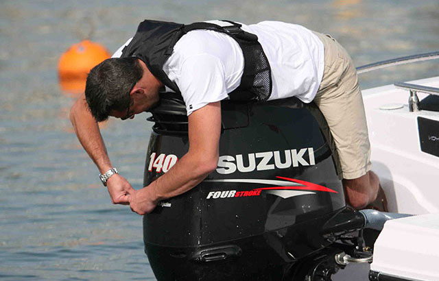 Man working on outboard engine