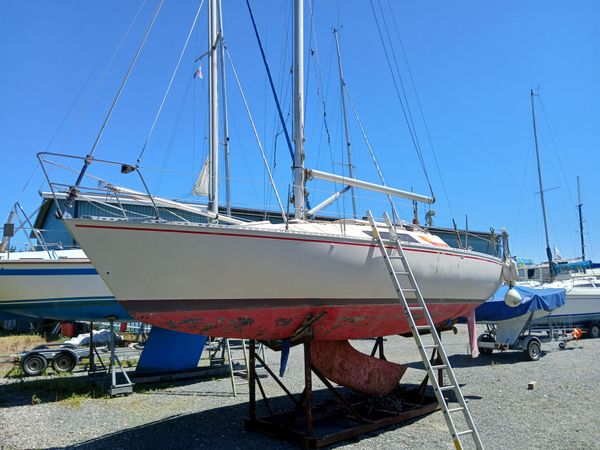 A white Beneteau First with red hull with lifting keel