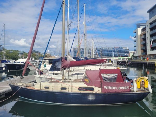 A blue, red and white Contessa sailing boat is moored in Portishead harbour