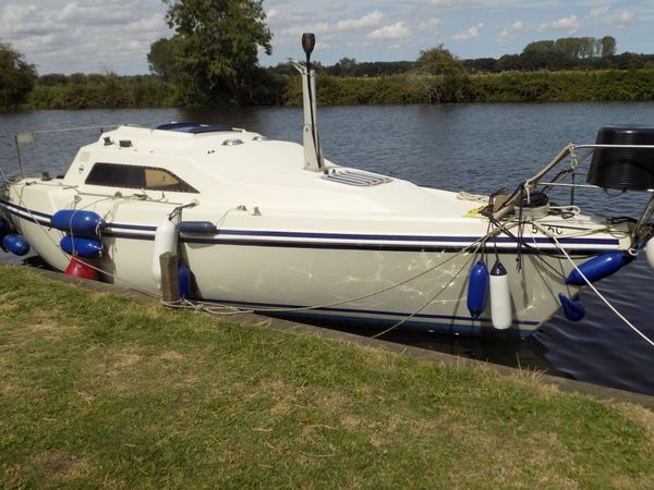 A Hunter Horizon 26 is moored up along the riverbank and the broads