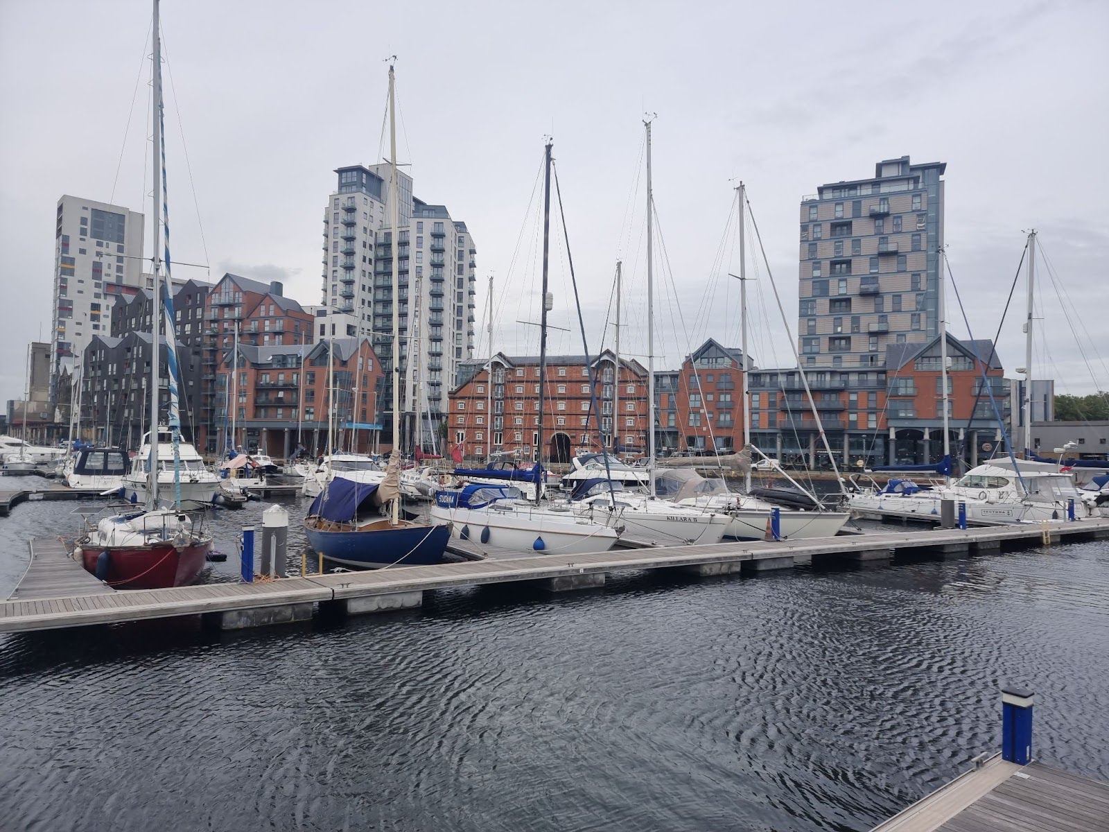 Ipswich harbour waters are still, with sail boats moored against a grey sky