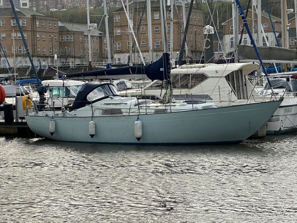 A pale green Nicholson sailing boat is mored in Cardiff harbour