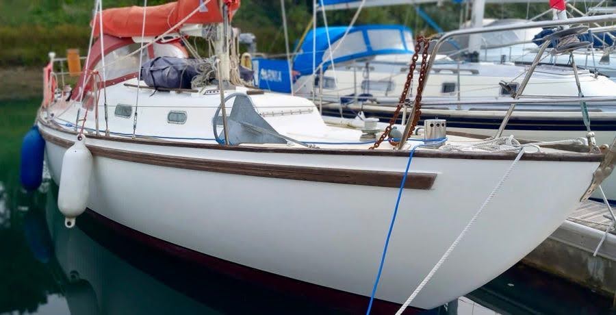 A white Rival 32 is moored on a UK country waterway