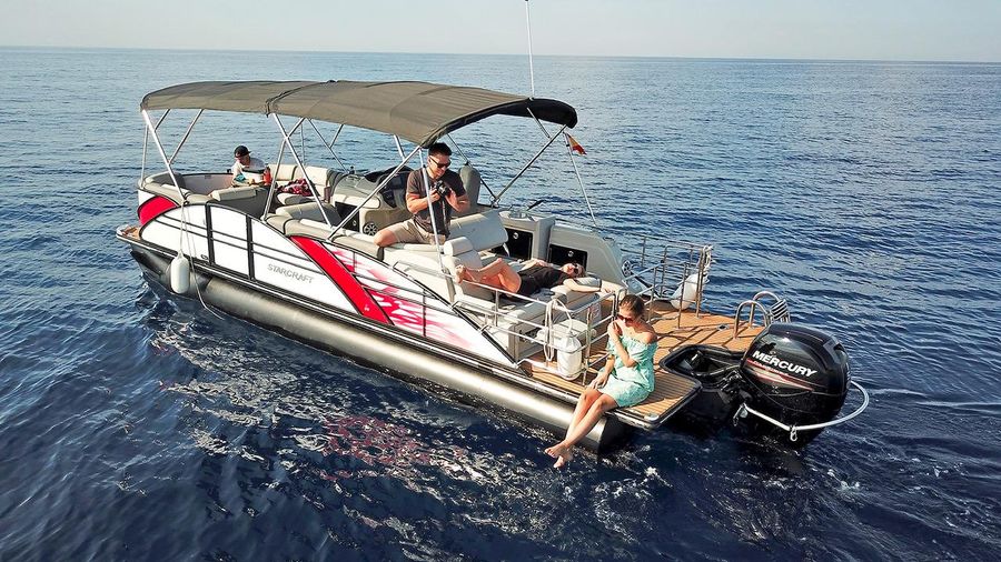 People relaxing on a pontoon boat at sea