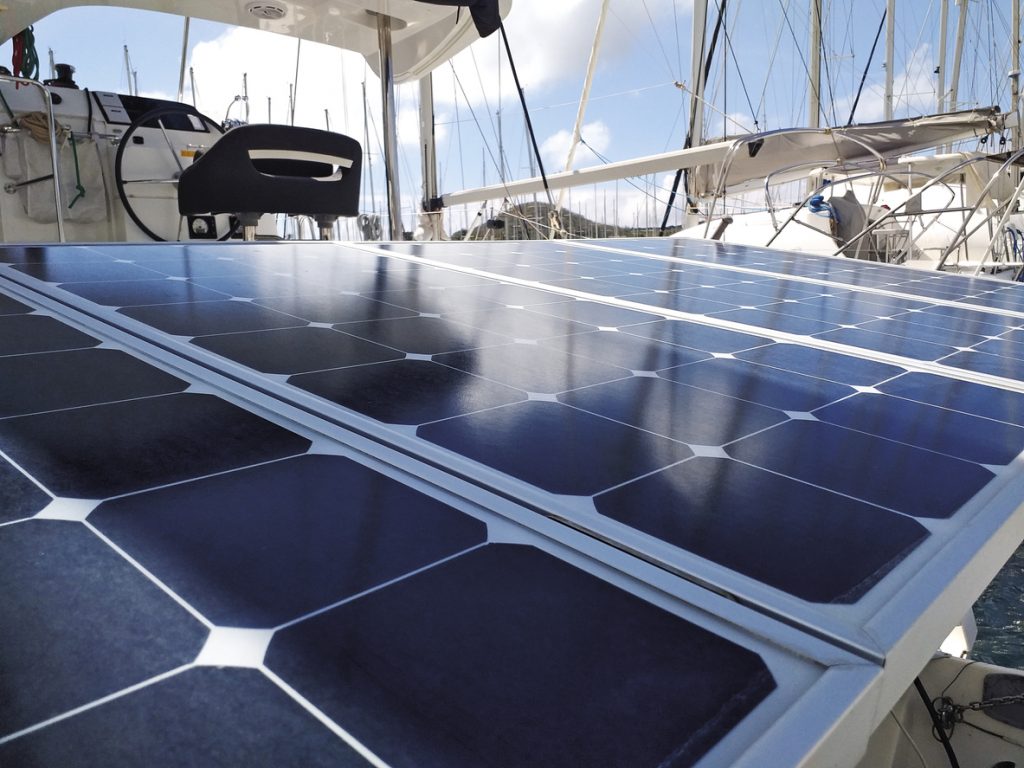 Solar panel detail of boat in marina in the French West Indies. Solar charging battery aboard a yacht. Close up of plate for photovoltaic solar energy on sailboat. Navigation instruments.