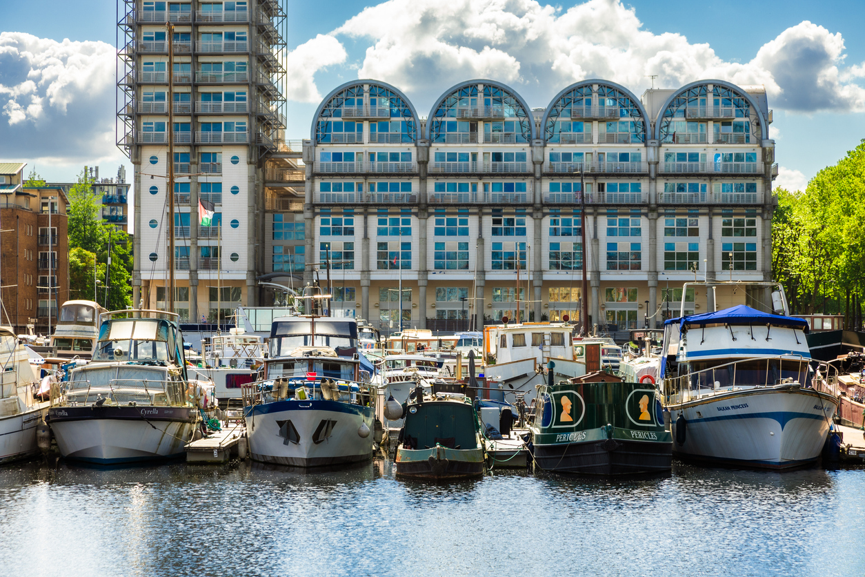 Houseboats moored up on the calm waters of Surrey Quays in Rotherhithe, London, UK.