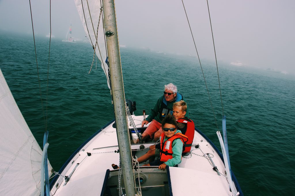 grandfather with grandchildren on a sailing boat